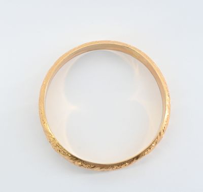 gros plan d'une bague en or sur une surface blanche