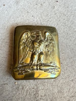 une image représentant une assiette en or sur laquelle figure un aigle