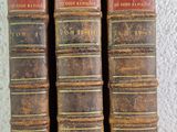 trois vieux livres posés sur une table l'un à côté de l'autre