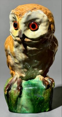 a ceramic owl sitting on top of a green object