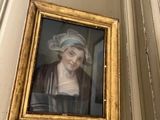 une photo d'une femme coiffée d'un chapeau, accrochée au mur