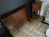 un lit avec une tête de lit en bois et une table de chevet