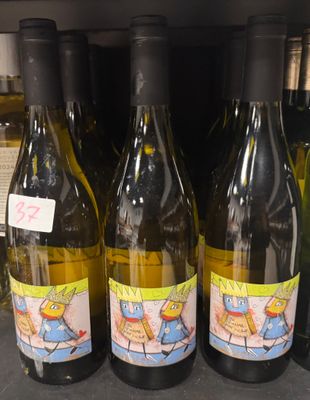 plusieurs bouteilles de vin sont alignées sur une étagère dans un magasin