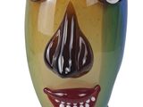 un vase coloré orné d'un visage, posé sur un socle