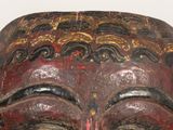 a close up of a wooden mask on a table
