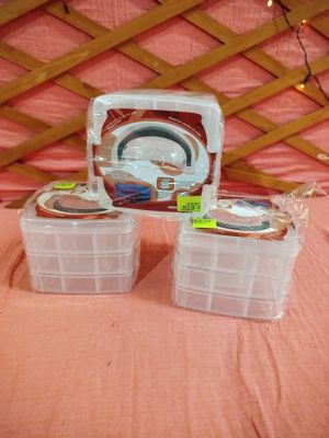 trois récipients en plastique posés sur un lit recouvert d'une couverture rose
