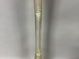 a tall glass vase with a green flower in the middle