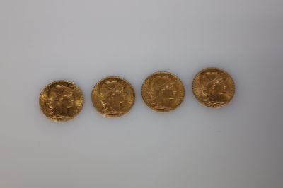 un groupe de cinq pièces d'or posées sur une surface blanche