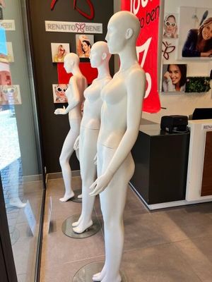 trois mannequins qui se tiennent devant la vitrine d'un magasin