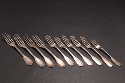 six fourchettes sont disposées en rangée sur une surface noire