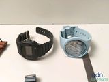 two watches and a watch case sitting on a table