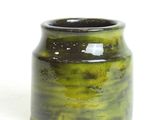 a green vase that is sitting on a white surface