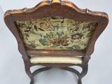 an old wooden chair with a floral upholstered seat