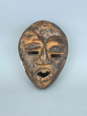 gros plan d'un masque en bois sur une surface blanche