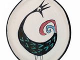 a plate with a bird painted on it on a white background