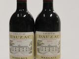 two bottles of red wine sitting next to each other on a white surface