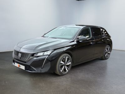 a black car is parked in a large room with a white wall