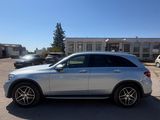 a silver mercedes suv parked in a parking lot in front of a building