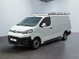 La camionnette blanche est garée dans une grande pièce équipée d'un ventilateur de plafond.