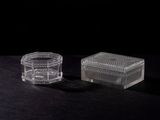 two clear glass containers sitting on top of a black surface