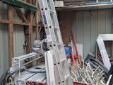 une photo d'un garage avec une échelle et un tas de bric-à-brac