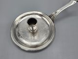an antique silver plate with a candle holder on top of it