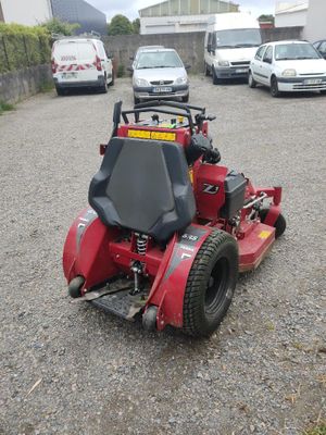une tondeuse à gazon rouge garée sur un parking