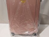 a pink suitcase that is wrapped in plastic and sitting on a table