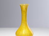 a yellow vase that is sitting on a table