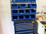 une armoire à outils bleue surmontée de nombreux bacs