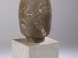 sculpture of a rock on top of a block on a white surface