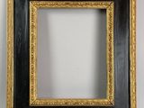 a black and gold frame with a gold border on a white wall