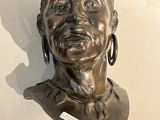 un buste en bronze représentant une femme, exposé dans un musée