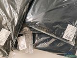 a pile of bags of black plastic sitting on top of a table