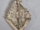 an old silver broochle with a bear and a sword on it