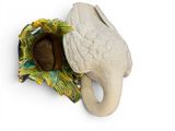 an elephant figurine that is sitting on a white surface