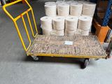 many rolls of toilet paper on a cart in a warehouse