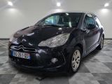 La petite voiture noire est garée dans le garage, sur le sol à damier.