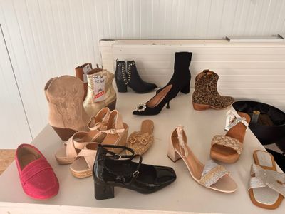 Plusieurs paires de chaussures pour femmes sont alignées sur une table