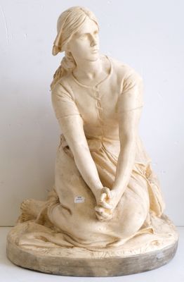 une statue de femme assise sur une table