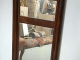 un miroir accroché au mur à côté d'une chaise