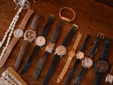 many different types of watches on a wooden table