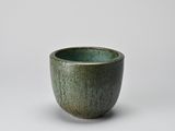 green glazed bowl with a black rim on a white background
