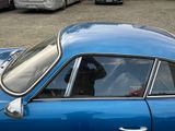 a blue car parked in a parking lot with other cars in the background
