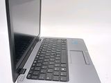 a silver laptop with a black keyboard on a white surface