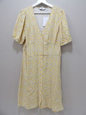 a yellow and white floral dress hanging on a hanger