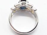 a close up of a ring with a blue and yellow diamond