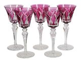 four pink wine glasses sitting next to each other on a white surface