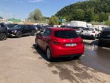 a red car parked in a parking lot with other cars