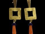 une photo d'une paire de boucles d'oreilles ornées de perles orange et bleues